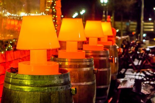 beautiful street decorations, line of lighted red lamps on wooden barrels, outdoor decoration