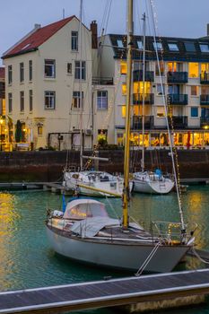 the docks of Vlissingen, a boat decorated with lights, lighted city scenery in the evening, Zeeland, The Netherlands