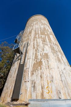 Old disused water tower of the abandoned asylum showing signs of salt seepage efflorescence through its concrete walls