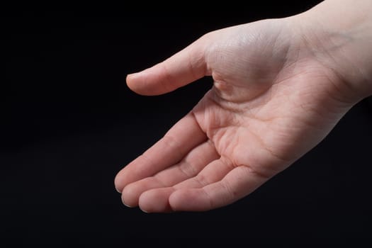 Five fingers of a child hand partly seen in black background