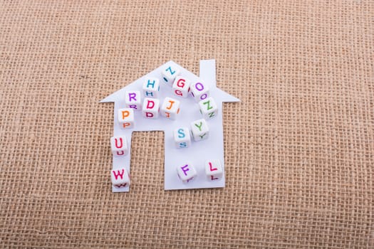 Letter cubes on house shape cut out of paper