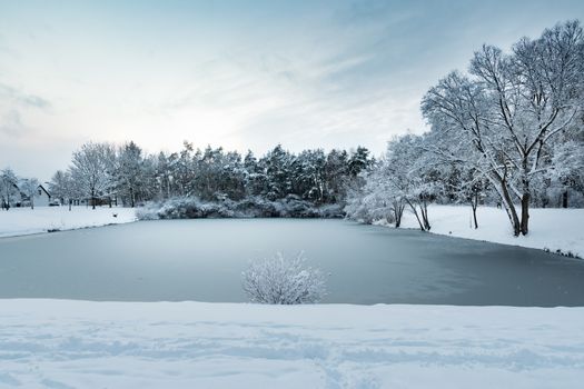 Image of a pond with trees and heavy snow in village Gernlinden, Bavaria, Germany in winter