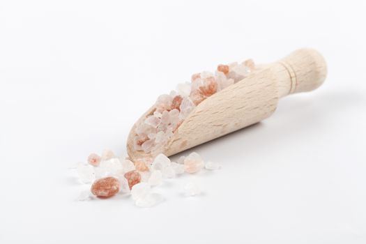 Himalayan Salt Raw Crystals Pile with Brown Wood Spice Scoop Isolated on White Background