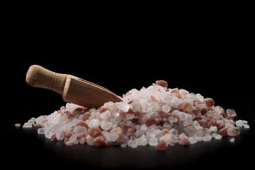 Broen Wood Spice Spoon On Salt Crystals Isolated on Black Background