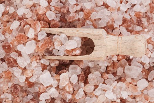 Himalayan Salt Raw Crystals Pile with Brown Wood Spice Scoop Isolated on White Background