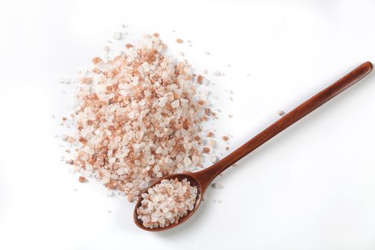 Himalayan Salt Raw Crystals Pile with Brown Wood Spoon Isolated on White Background