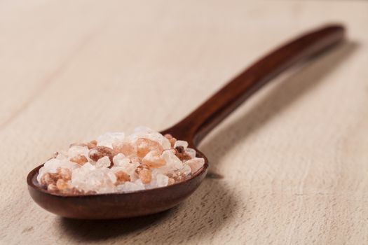Brown Wood Spoon on Wood full with Himalayan Salt