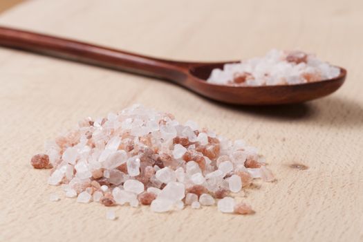 Pink Himalayan Salt on Wood Cutting Board and Spoon in the Background