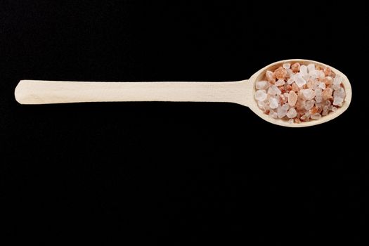 Rustic Wood Spoon With Himalayan Salt Raw Crystals on Dark Background