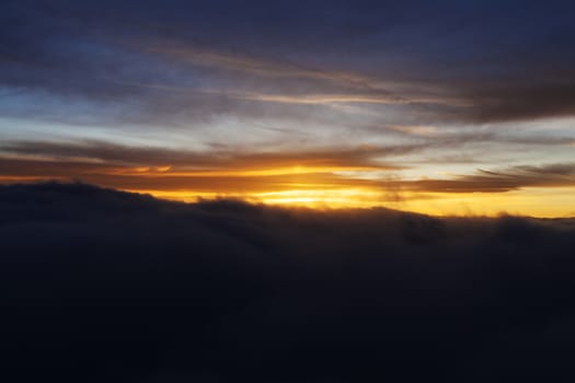 Dramatic Sunrise over fluffy clouds with bright rays of light