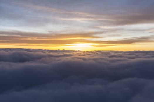 Sunrise over fluffy clouds with bright rays of light