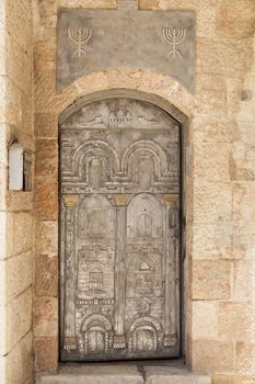 Silver and gold metal door with judaism siymbols and the gates of  jerusalm