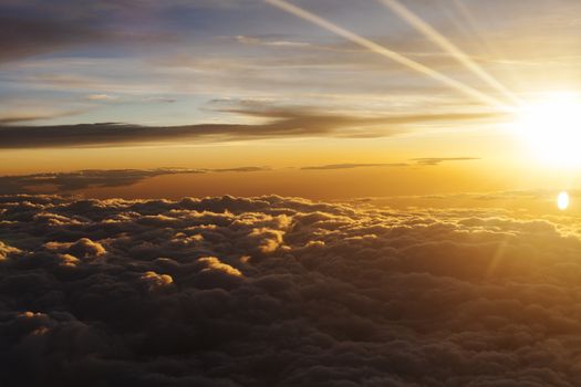 Sunrise over flufy clouds with bright rays of light