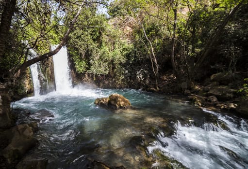 Blue water in waterfall pool in a middle of the forest