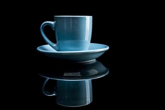 Blue coffee cup isolated on black background with reflexion