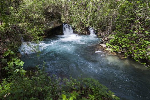 Blue water in waterfall pool in a middle of the forest