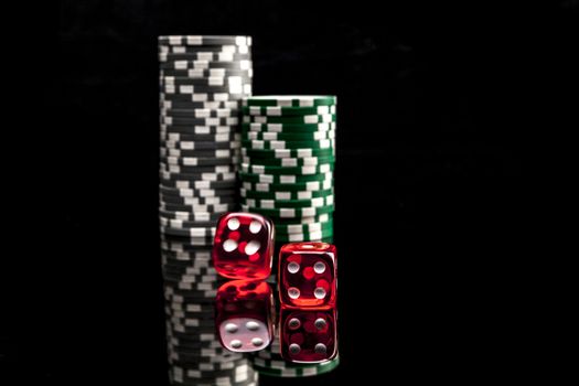 Dice and chips isolated on black background with reflexion