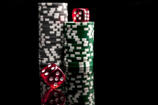 Dice and chips isolated on black background with reflexion