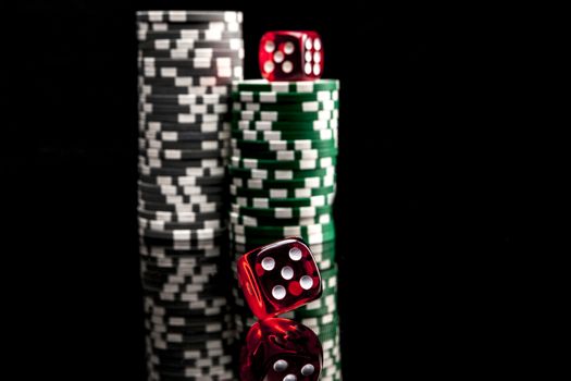 Dice and chips isolated on black background with reflexion