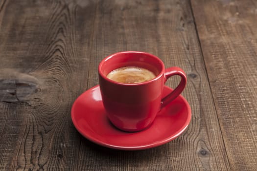 Coffee in red cup on wood table