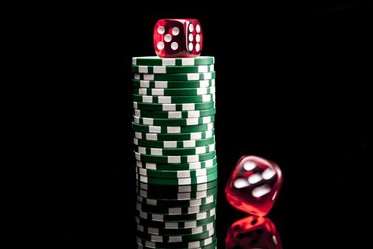 Dices and chips isolated on black background with reflexion