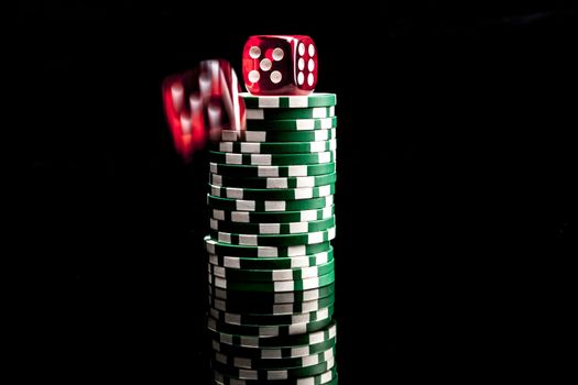 Dice and chips isolated on black background with reflexion