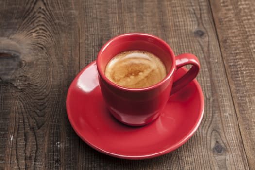 Coffe in red mug on wood table