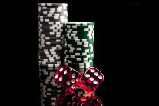 Dice and chips isolated on black background with reflexion