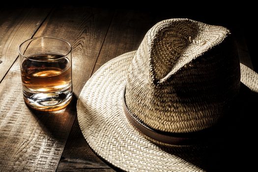 Alcohol and hat on table with shadow