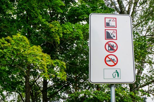 Sign at Koknese castle. Warning board in green park for information, Koknese, Latvia.