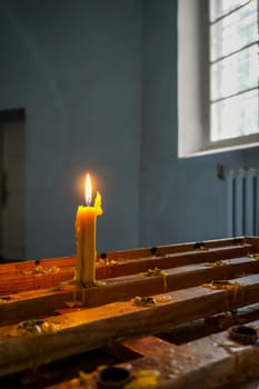Burning candle at Koknese Evangelical Lutheran Church. Evangelic Lutheran Church in Koknese, Latvia. Interior of Koknese church. Church was built in 1687. 