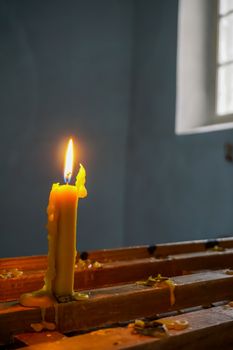 Burning candle at Koknese Evangelical Lutheran Church. Evangelic Lutheran Church in Koknese, Latvia. Interior of Koknese church. Church was built in 1687. 