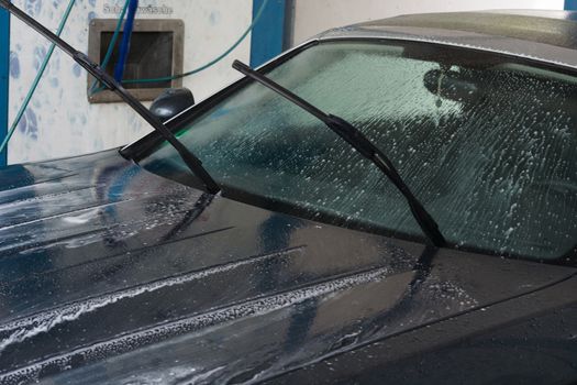 Manual car wash with pressurized water in the car wash outside.