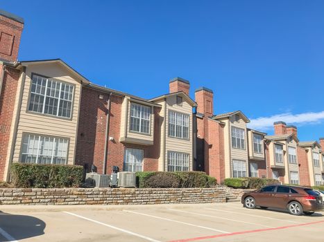 Typical apartment complex near Dallas, Texas, USA with uncovered parking lots and high retaining wall