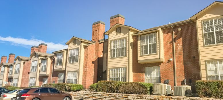 Panorama view typical apartment complex near Dallas, Texas, USA with uncovered parking lots and high retaining wall