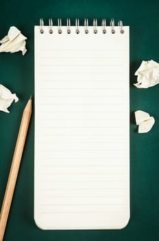 Open blank diary notebook with wooden pencil on green board for your text or message.