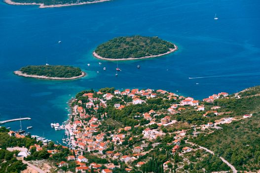 Aerial view of smaal town with harbor on the Adriatic coast in Croatia, sailing boats in harbor, emerald blue sea, vacation and tourism concept