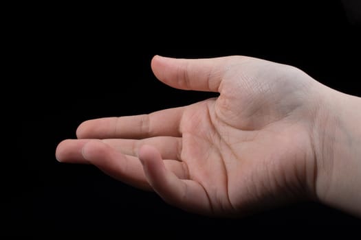 Five fingers of a child hand partly seen in black background