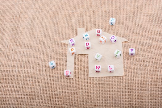 Letter cubes on house shape cut out of paper