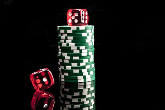 Dice and chips isolated on black background with reflexion