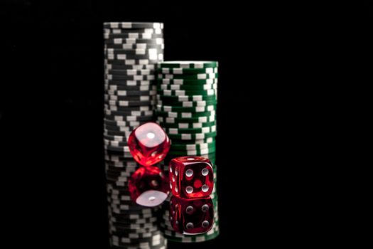 Dice and chips isolated on black background with reflexion