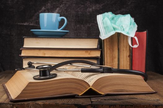 Old Books on wood table with notebook and hourglass