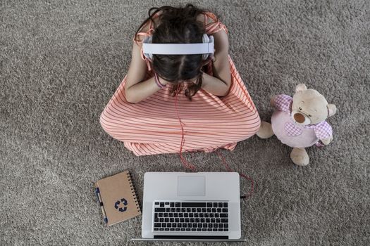 Child with a pc, a notebook and a bear