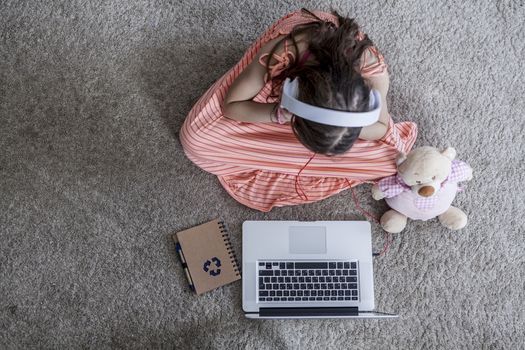 Kid sitting on the floor watching on laptop