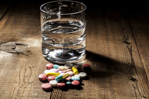 Pills and water on table with shadow