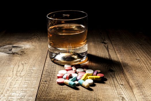 Alcohol and pills with shadow and little black background