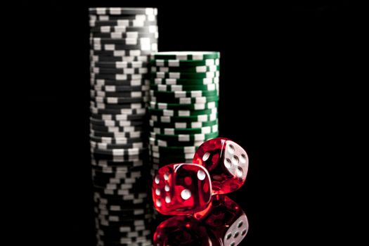 Dice and chips isolated on black background with reflexion