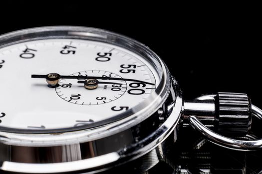 Chronometer isolated on black background with reflexion