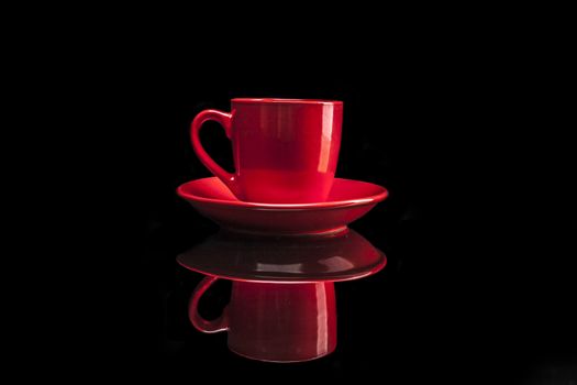 Red cup isolated on black background with reflexion