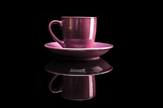 Pink cup isolated on black background with reflexion